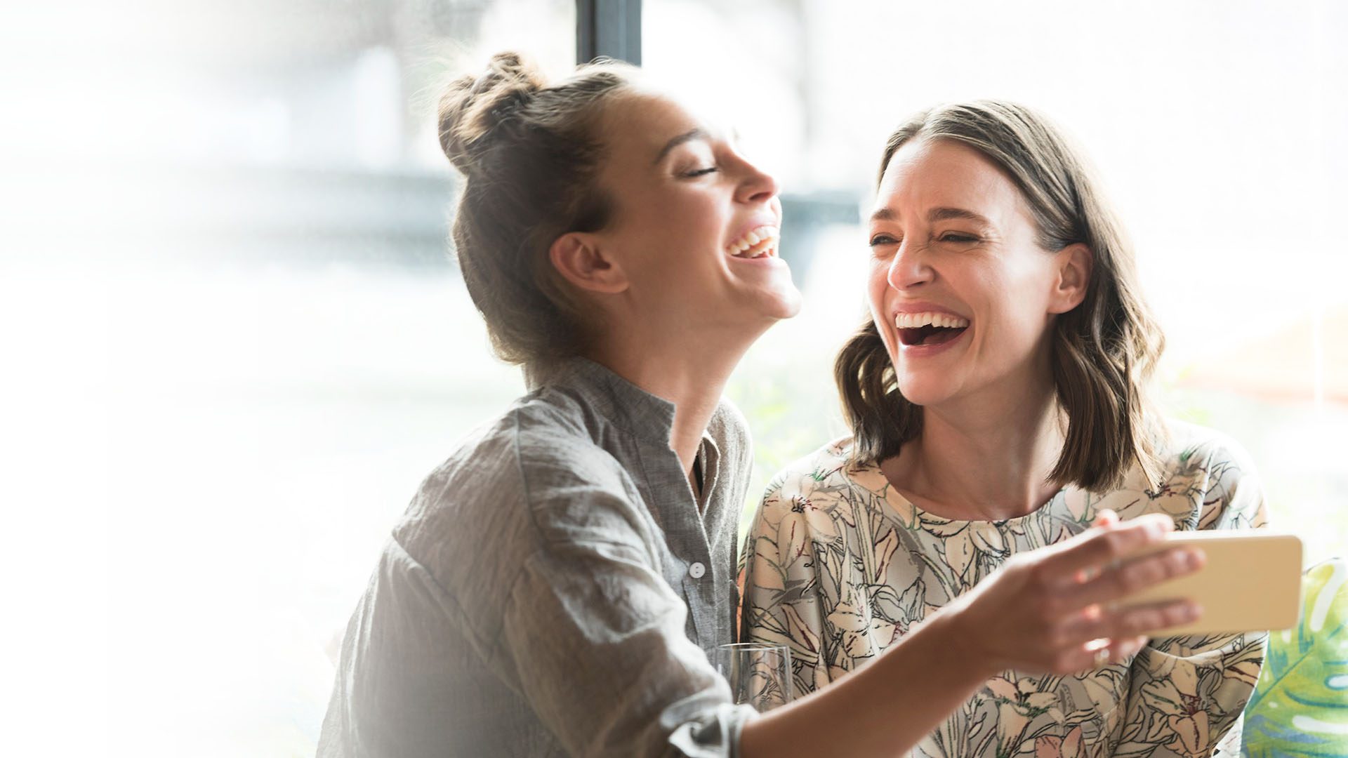 two-women-laugh-happy-bg empowered-employees